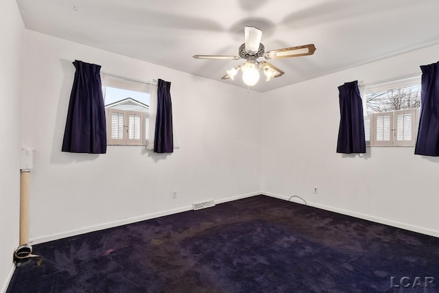 empty room featuring plenty of natural light, ceiling fan, and carpet floors