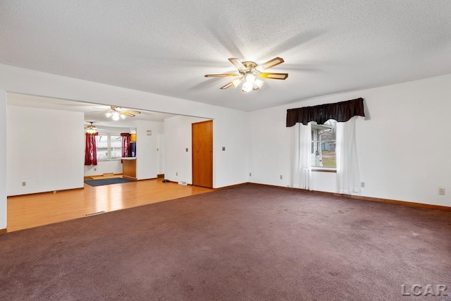 empty room featuring a healthy amount of sunlight, a textured ceiling, and light hardwood / wood-style floors