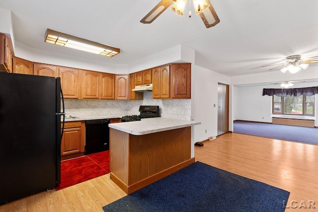 kitchen featuring black appliances, light hardwood / wood-style flooring, decorative backsplash, ceiling fan, and kitchen peninsula