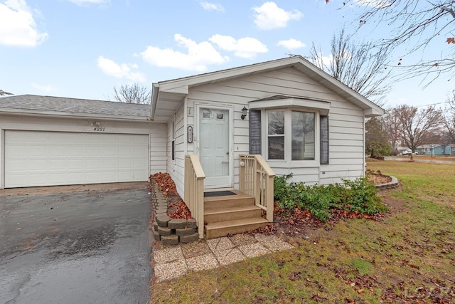 view of front of house with a garage and a front lawn