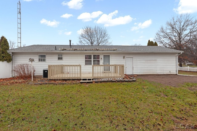 rear view of property featuring a lawn, central AC unit, and a wooden deck