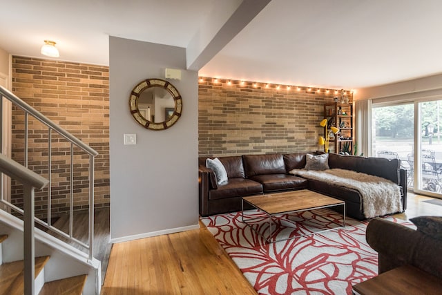 living room with hardwood / wood-style floors and brick wall