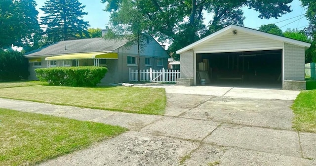 view of front of house featuring an outbuilding, a front lawn, and a garage