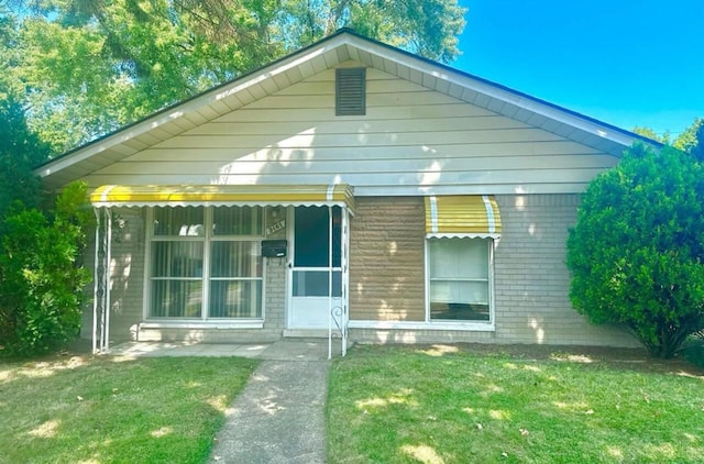 bungalow-style home with a front yard