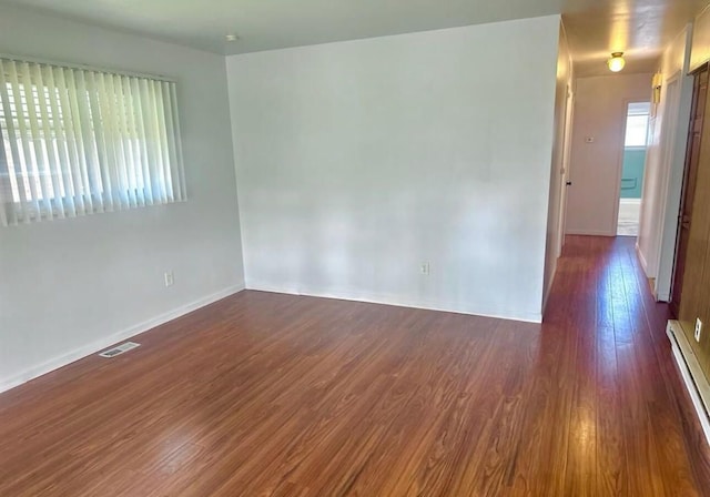 spare room featuring dark hardwood / wood-style flooring and a baseboard radiator