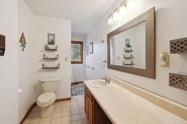 bathroom with tile patterned flooring, vanity, and toilet