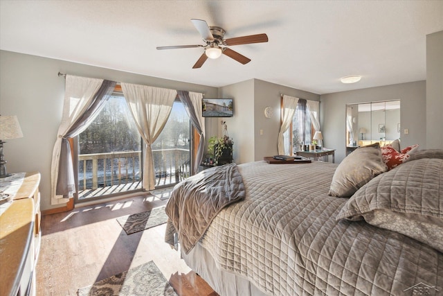 bedroom with access to exterior, hardwood / wood-style floors, and ceiling fan