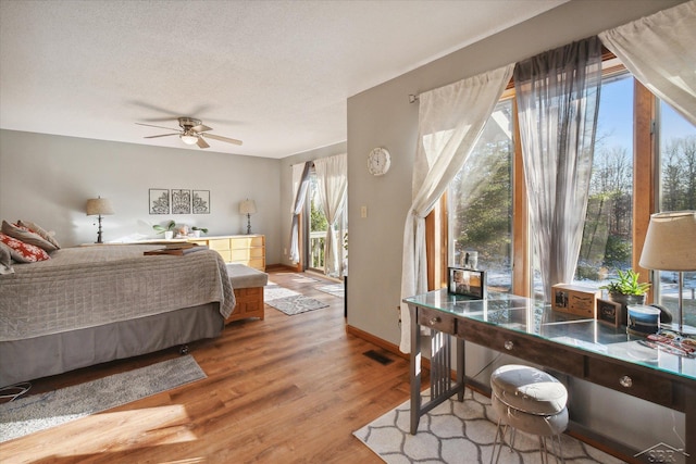 bedroom featuring hardwood / wood-style floors, a textured ceiling, and ceiling fan