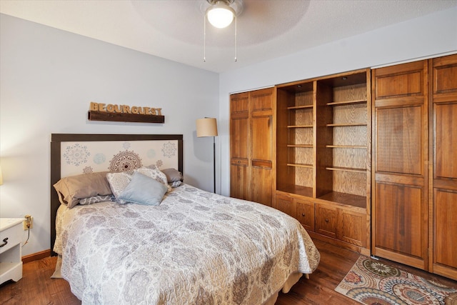 bedroom featuring ceiling fan, dark wood-type flooring, and a closet