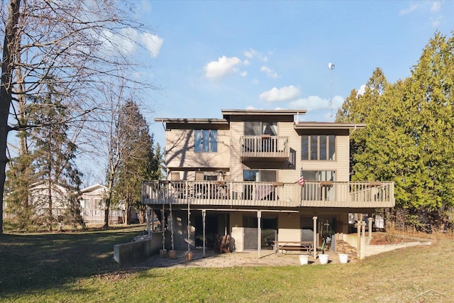 back of property featuring a lawn, a balcony, a deck, and a patio