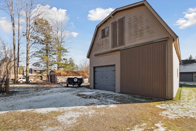 snow covered property with an outbuilding and a garage