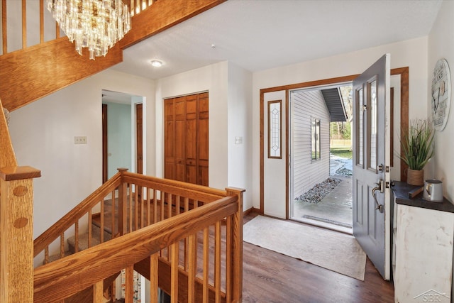 entryway featuring dark wood-type flooring and a chandelier