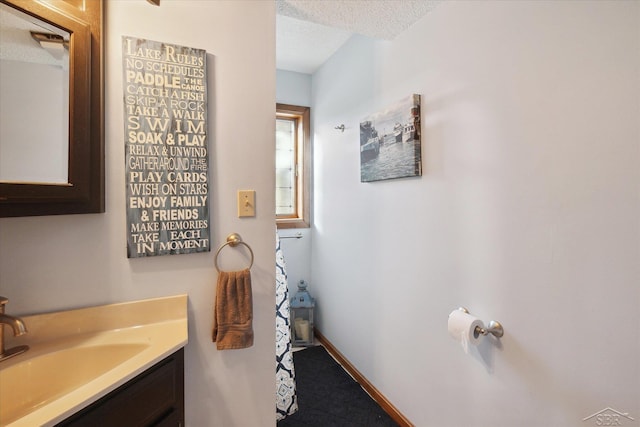 856 Pawtucket Dr, Hope, MI 48628 - bathroom with a textured ceiling, vanity, and baseboards