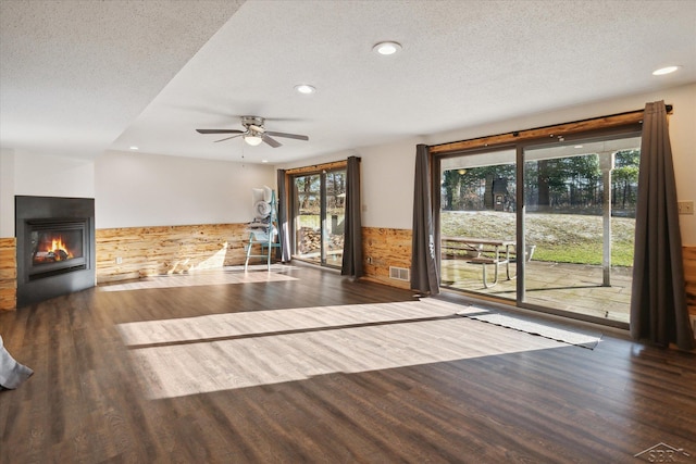 856 Pawtucket Dr, Hope, MI 48628 - unfurnished living room with a textured ceiling, a wainscoted wall, visible vents, ceiling fan, and wood finished floors