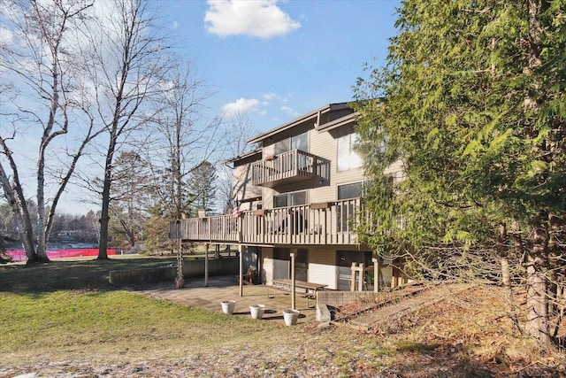 rear view of property with a wooden deck and a balcony