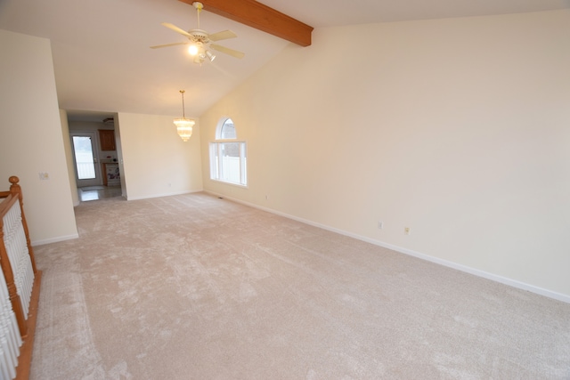 empty room with vaulted ceiling with beams, a wealth of natural light, ceiling fan, and light colored carpet