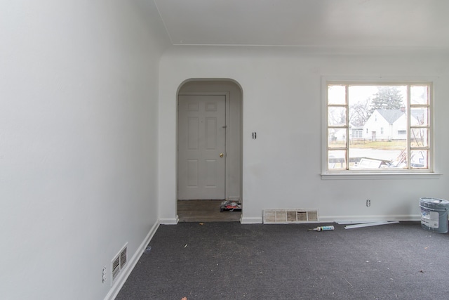 unfurnished room with dark carpet