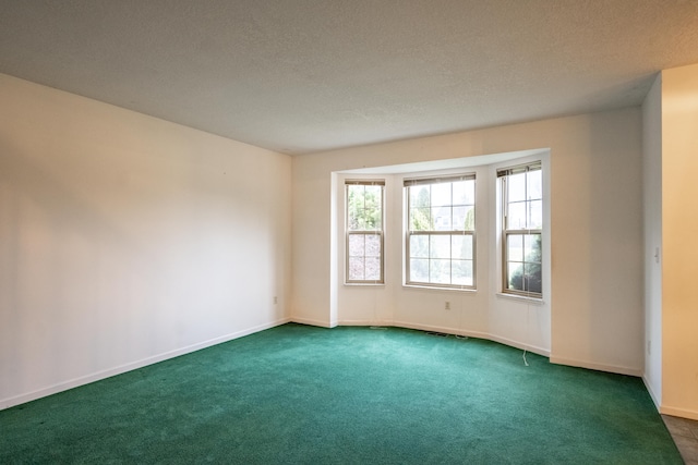 carpeted empty room with a textured ceiling