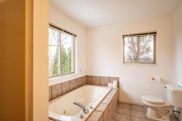 bathroom with tile patterned floors, toilet, and tiled tub