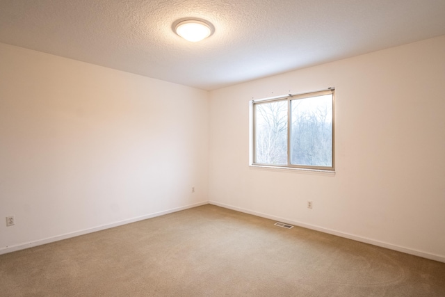 carpeted spare room featuring a textured ceiling