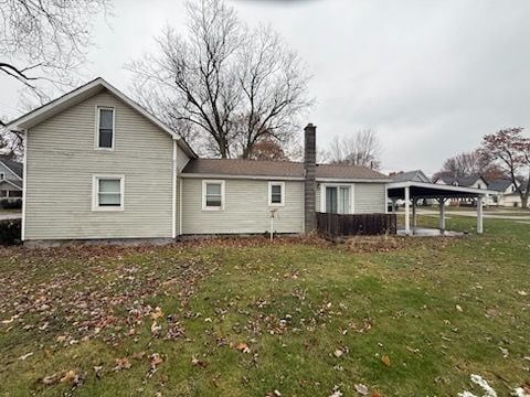 back of property featuring a yard and a carport