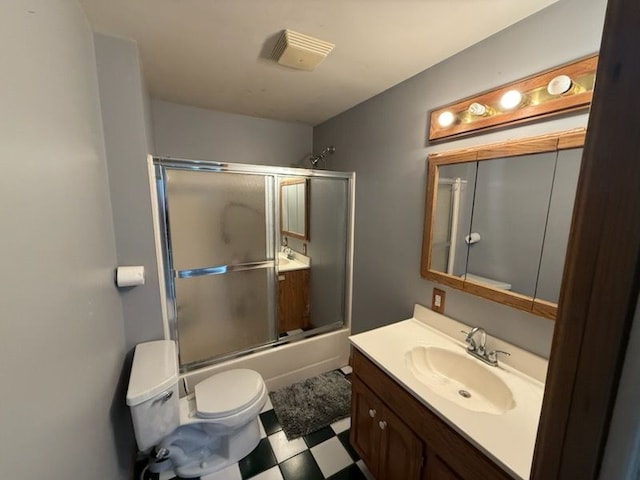 full bathroom with vanity, bath / shower combo with glass door, and toilet