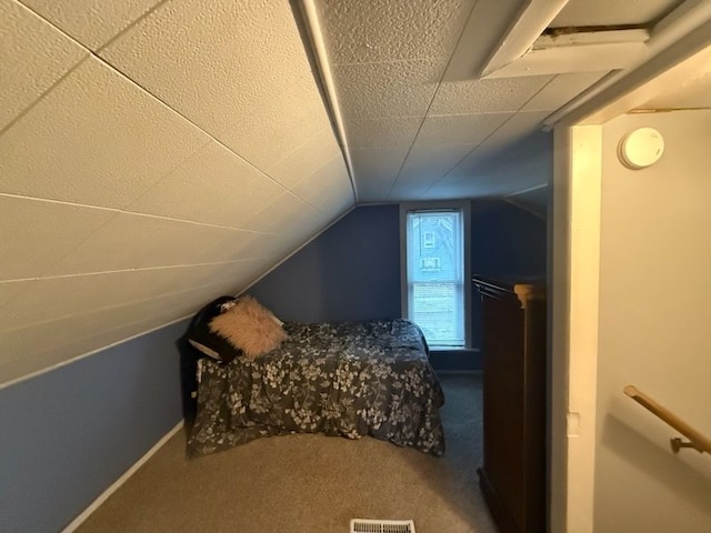 carpeted bedroom with lofted ceiling