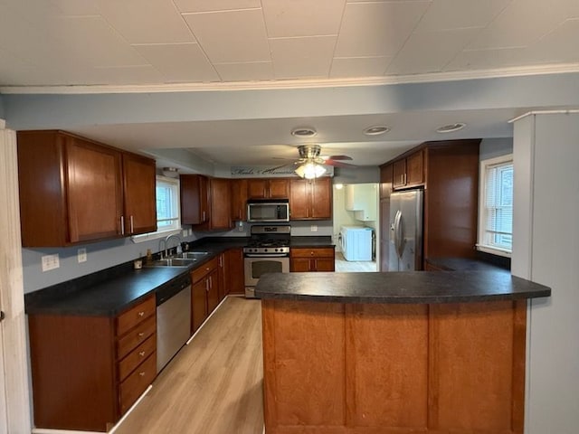 kitchen featuring stainless steel appliances, light hardwood / wood-style flooring, ornamental molding, and sink