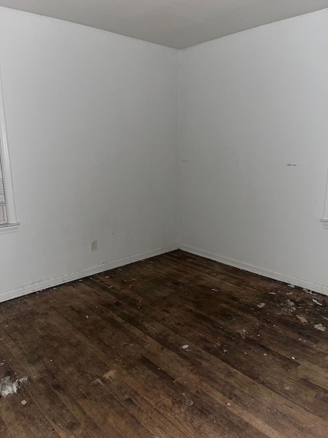 unfurnished room with dark hardwood / wood-style flooring