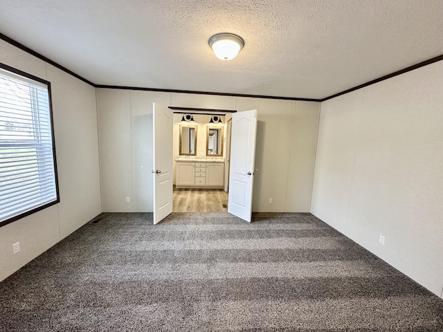 unfurnished bedroom featuring crown molding, carpet floors, and a textured ceiling