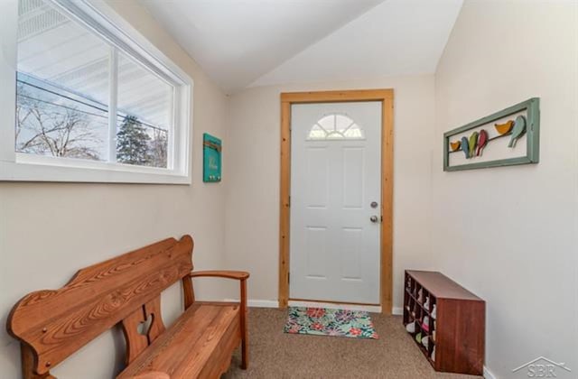 entryway with light colored carpet and vaulted ceiling