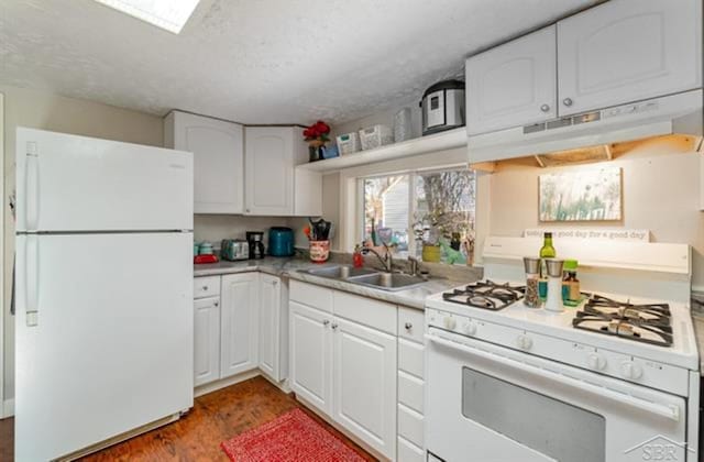 kitchen featuring white appliances, dark wood-type flooring, sink, a textured ceiling, and white cabinetry