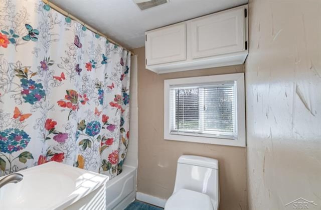 bathroom with toilet and shower / bathtub combination with curtain