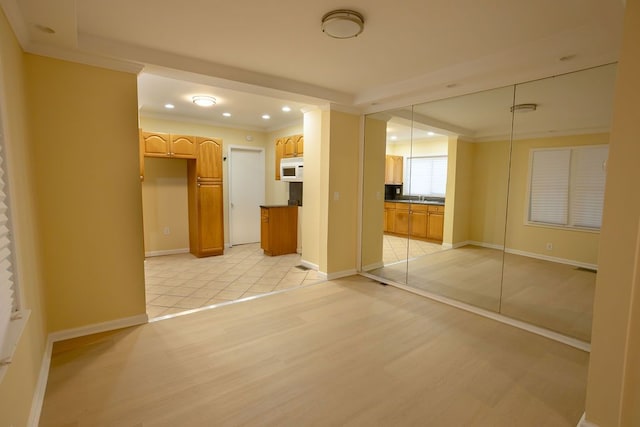 interior space featuring crown molding, a closet, and light wood-type flooring