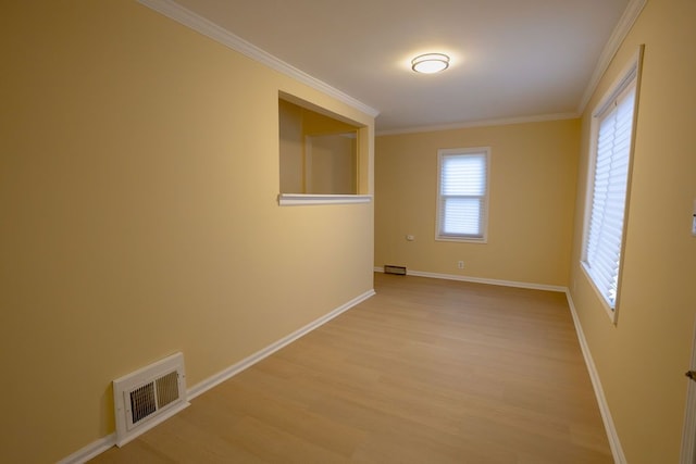 unfurnished room with ornamental molding and light wood-type flooring