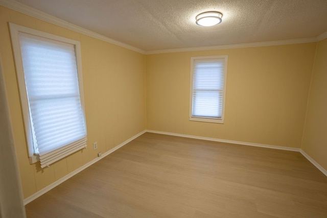 unfurnished room featuring light hardwood / wood-style floors, a textured ceiling, and ornamental molding