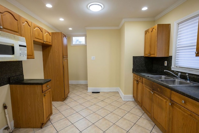 kitchen with light tile patterned floors, tasteful backsplash, ornamental molding, and sink