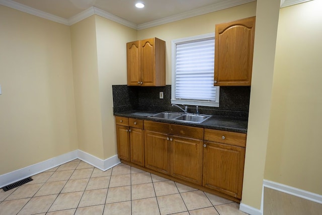 kitchen with light tile patterned floors, tasteful backsplash, crown molding, and sink