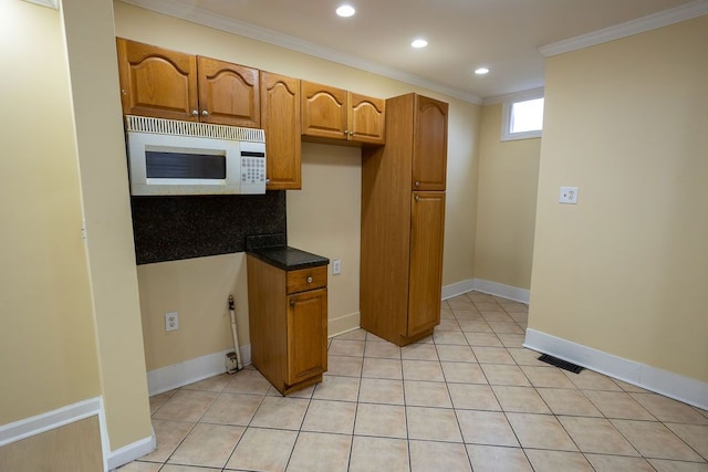 kitchen with light tile patterned floors, tasteful backsplash, and ornamental molding