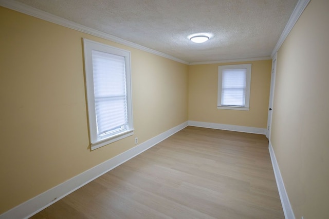 empty room with ornamental molding, a textured ceiling, and light hardwood / wood-style flooring