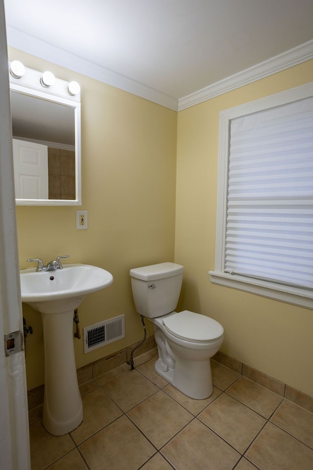 bathroom featuring tile patterned flooring, toilet, and ornamental molding