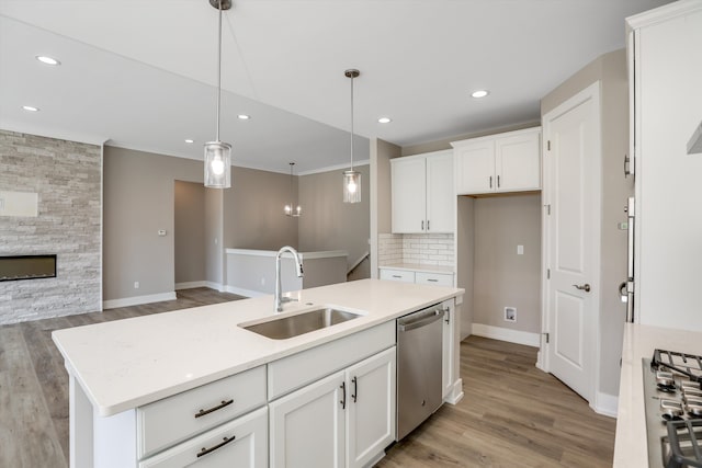 kitchen with dishwasher, sink, decorative light fixtures, a center island with sink, and white cabinets