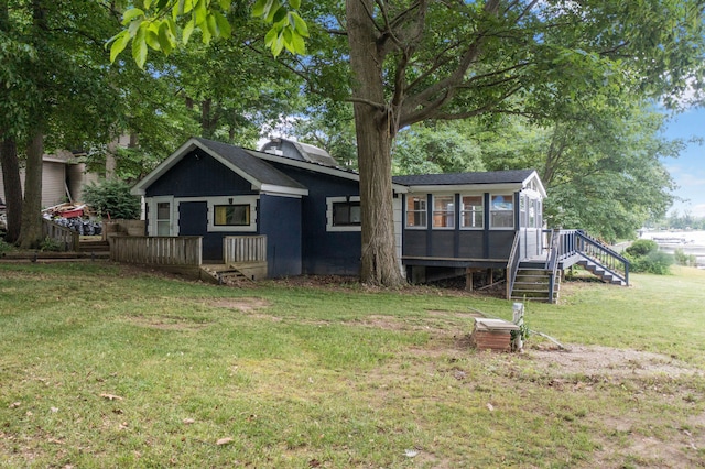 rear view of property featuring a yard and a sunroom