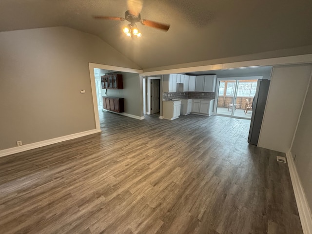 unfurnished living room featuring ceiling fan, dark hardwood / wood-style flooring, and lofted ceiling