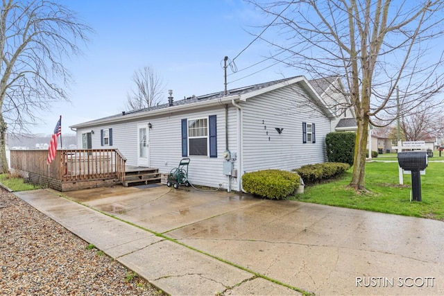 2008 Parker Dr, Wayland, MI 49348 - rear view of house with a wooden deck, a patio area, and a lawn
