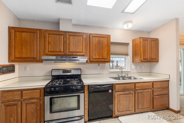 2008 Parker Dr, Wayland, MI 49348 - kitchen with stainless steel gas range oven, under cabinet range hood, a sink, black dishwasher, and brown cabinets