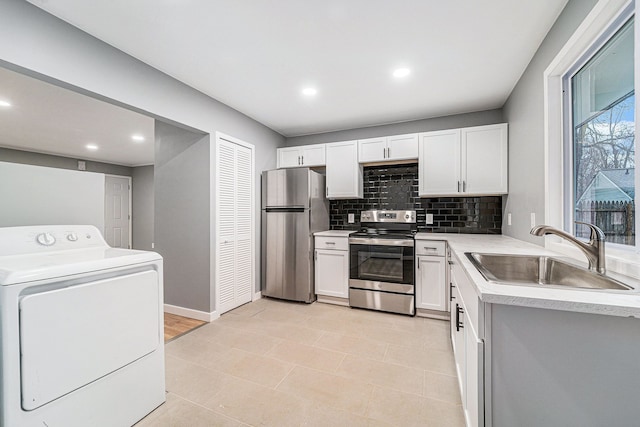 kitchen with white cabinetry, sink, stainless steel appliances, backsplash, and washer / clothes dryer