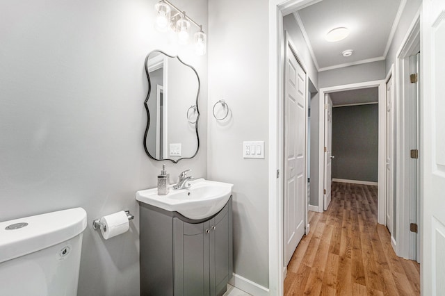 bathroom featuring hardwood / wood-style floors, vanity, toilet, and crown molding