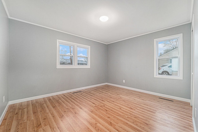 unfurnished room with crown molding, a healthy amount of sunlight, and light hardwood / wood-style floors