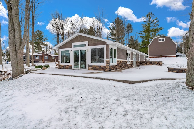 1571 Loebrich Dr, Gladwin, MI 48624 - snow covered back of property with stone siding